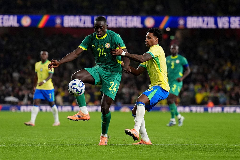 | Photo: John Walton/PA via AP : Senegal's Antoine Mendy, left, and Brazil's Rodrygo battle for the ball during an international soccer match between Brazil and Senegal at the Emirates Stadium, London.