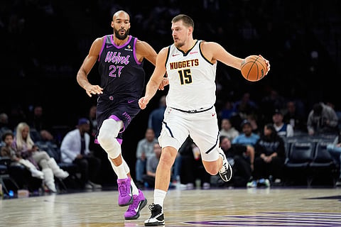 Denver Nuggets center Nikola Jokic (15) works toward the basket as Minnesota Timberwolves center Rudy Gobert (27) defends during the second half of an NBA basketball game in Minneapolis. 