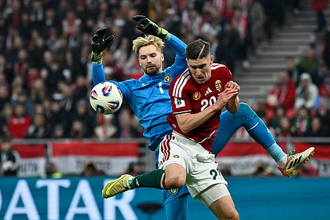 Hungary's Roland Sallai is challenged by Ireland goalkeeper Caoimhin Kelleher during the World Cup 2026 group F qualifying soccer match between Hungary and Ireland in Budapest, Hungary.