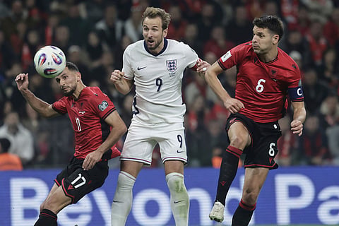 England's Harry Kane, center, scores his side's second goal as Albania's Naser Aliji, left, and Berat Djimsiti try to stop him during the World Cup 2026 group K qualifying soccer match between Albania and England, in Tirana, Albania.