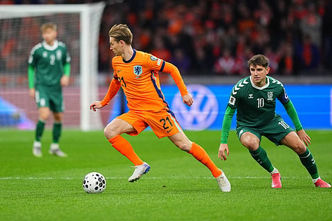 Netherlands' Frenkie de Jong, left, dribbles the ball past Lithuania's Fedor Cernych during a World Cup 2026 group G qualifying soccer match between Netherlands and Lithuania in Amsterdam, Netherlands.