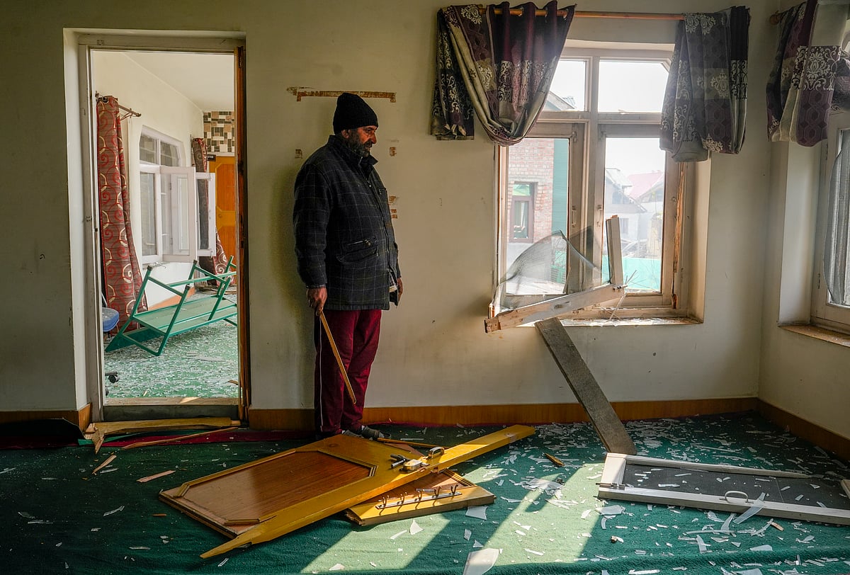 PTI Photo/S Irfan : Srinagar: A man stands near a damaged window of his house in the aftermath of a blast at the Nowgam police station, on the outskirts of Srinagar, Jammu and Kashmir, Saturday, Nov. 15, 2025. An accidental blast occurred on the premises of the police station on Friday night while personnel were taking samples of explosive material seized from Faridabad in connection with a "white-collar" terror module case, officials said.