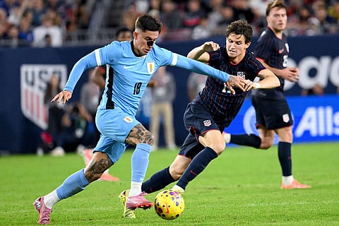 Uruguay's Brian Rodriguez (18) and United States' Brenden Aaronson (11) battle for the ball during the second half of an international friendly soccer game in Tampa, Fla.