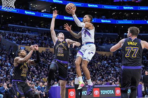 Utah Jazz guard Keyonte George (3) goes up for a basket against Los Angeles Lakers guard Austin Reaves (15) as guard Luka Doncic (77) and forward Rui Hachimura watch during the first half of an NBA basketball game in Los Angeles.