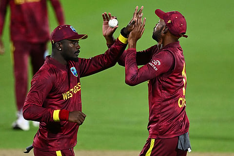 West Indies' Jayden Seales and Roston Chase, right, celebrate the wicket of New Zealand's Rachin Ravindra during their One Day International cricket match in Napier, New Zealand.