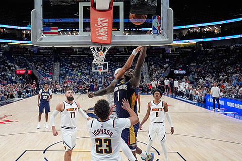 New Orleans Pelicans forward Zion Williamson (1) goes to the basket in front of Denver Nuggets forward Cameron Johnson (23) in the second half of an NBA basketball game in New Orleans. 