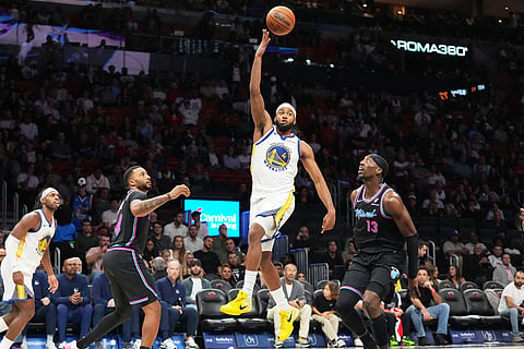 Golden State Warriors guard Moses Moody, center, passes the ball as Miami Heat guard Norman Powell, seance from left, and center Bam Adebayo (13) defend during the second half of an NBA basketball game in Miami. 