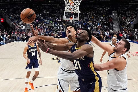 New Orleans Pelicans center Yves Missi (21) battles under the basket between Denver Nuggets forward Spencer Jones, left, and center Nikola Jokic in the second half of an NBA basketball game in New Orleans. 