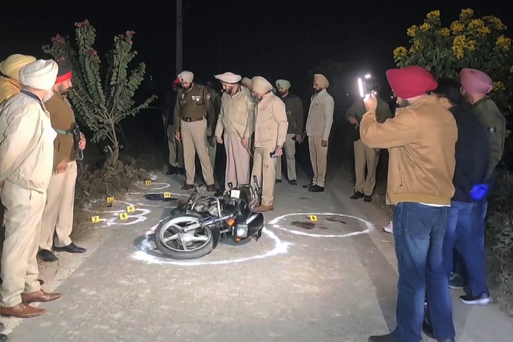 | Photo: PTI : Police Commissioner Gurpreet Singh Bhullar and other officials inspect the site where two youths on a motorcycle allegedly open fire on police during a late-night checkpoint inspection, in Amritsar. One of them succumbs to injuries while the other escapes, prompting a search operation, according to officials. 