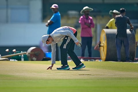 India's chief coach Gautam Gambhir examines the pitch ahead of the second test match between India and South Africa in Guwahati.