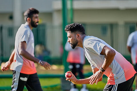 India's Mohammed Siraj, right, bowls as Jasprit Bumrah walks past at net during a practice session ahead of the second test match between India and South Africa in Guwahati.