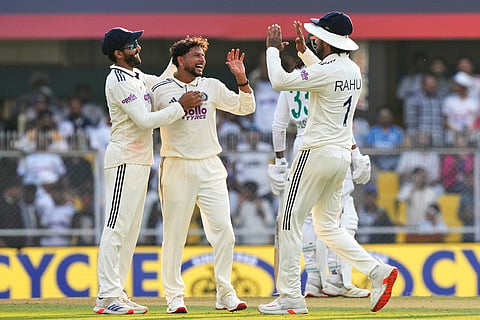 India's Kuldeep Yadav, centre, celebrates with teammates after the dismissal of South Africa's Wiaan Mulder on the first day of the second cricket test match between India and South Africa in Guwahati.