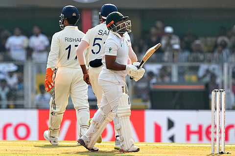 South Africa's captain Temba Bavuma, right, walks off the field after losing his wicket on the first day of the second cricket test match between India and South Africa in Guwahati.