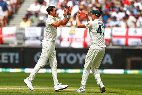 Australia's Mitchell Starc, left, celebrates with teammate Cameron Green the wicket of England's captain Ben Stokes on day two of the first Ashes cricket test match between Australia and England in Perth.