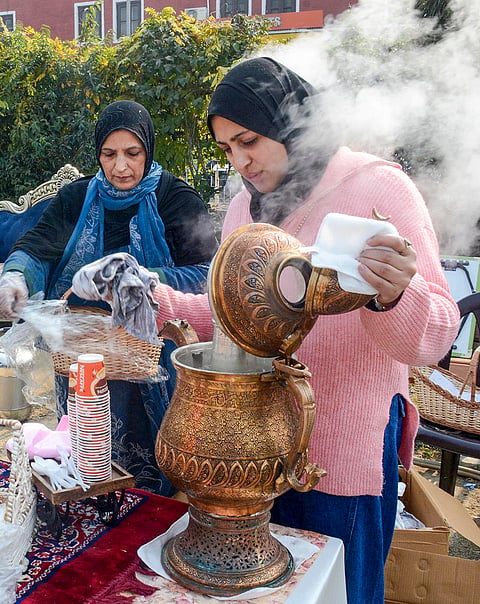 Women prepare traditional Kashmiri tea 'Noon chai' at a stall during at an exhibition organized to empower women, in Srinagar.