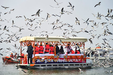 A flock of migratory birds flies over the boats at the Sangam, in Prayagraj.