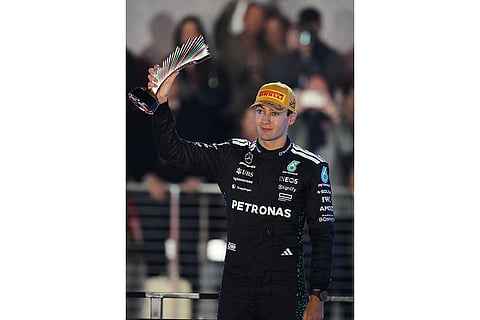 Third place finisher Mercedes driver George Russell of Great Britain celebrates with his trophy after the Formula One Las Vegas Grand Prix auto race in Las Vegas. 