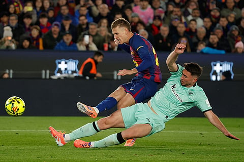 Barcelona's Dani Olmo shoots by Athletic Bilbao's Aymeric Laporte during a La Liga soccer match between Barcelona and Athletic in Barcelona, Spain.
