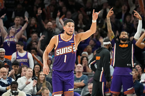 Phoenix Suns guard Devin Booker (1) gestures after making a 3-pointer against during the second half of an NBA basketball game against San Antonio Spurs in Phoenix.