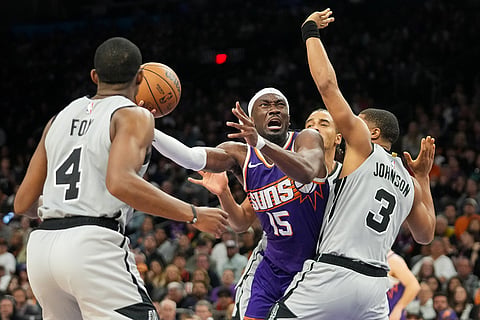 Phoenix Suns center Mark Williams (15) shoots between San Antonio Spurs guard De'Aaron Fox (4) and Keldon Johnson (3) during the second half of an NBA basketball game in Phoenix.