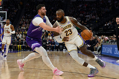 Los Angeles Lakers forward LeBron James (23) drives to the basket guarded by Utah Jazz center Jusuf Nurkic, right, during the first half of an NBA basketball game in Salt Lake City.