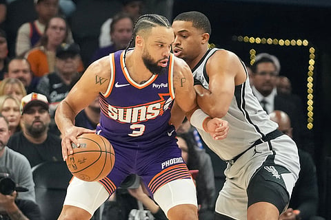 Phoenix Suns forward Dillon Brooks works his way towards the basket against San Antonio Spurs forward Keldon Johnson, right, during the first half of an NBA basketball game in Phoenix.