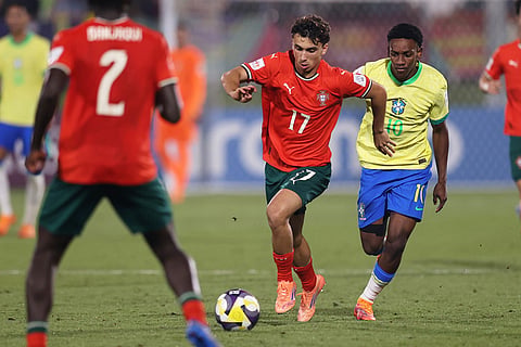 Portugal's Joao Aragao fights for the ball against Brazil's Gabriel Mec during the FIFA U17 World Cup semifinal soccer match between Portugal and Brazil in Doha, Qatar.