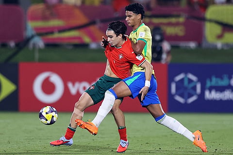 Brazil's Luccas Ramon fights for the ball against Portugal's Mateus Mide during the FIFA U17 World Cup semifinal soccer match between Portugal and Brazil in Doha, Qatar.
