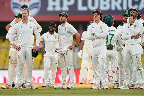 South Africa's players look for a third umpire's decision on the fourth day of the second cricket test match between India and South Africa in Guwahati.