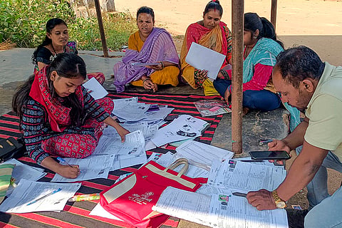 Booth Level Officers (BLOs) assist voters in filling out the enumeration forms for the special intensive revision (SIR) of electoral rolls, at Burundwada Semra village in Bastar district, Chhattisgarh.