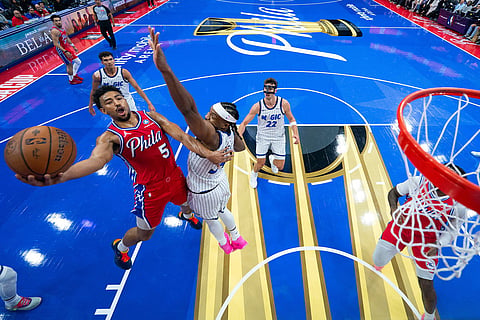 Philadelphia 76ers' Quentin Grimes, left, goes up for the shot against Orlando Magic's Wendell Carter Jr., right, during the first half of an NBA Cup basketball game in Philadelphia.