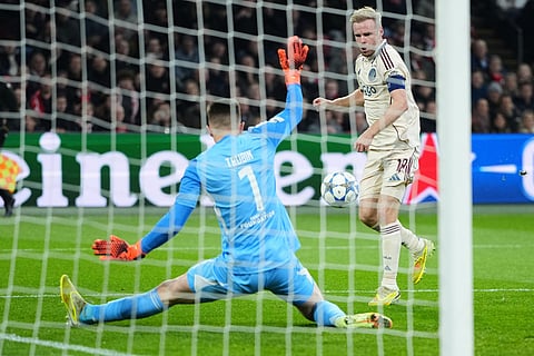 Benfica's goalkeeper Anatoliy Trubin makes a save in front of Ajax's Davy Klaassen during the Champions League opening phase soccer match between Ajax and SL Benfica in Amsterdam, Netherlands.