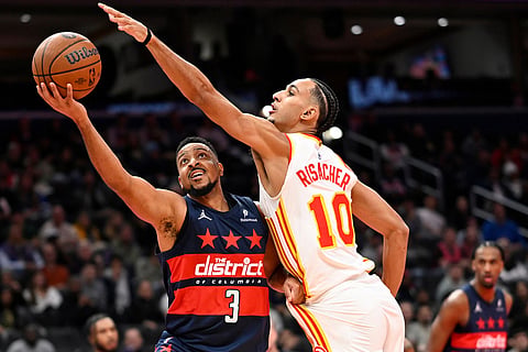 Washington Wizards guard CJ McCollum (3) attempts a shot against Atlanta Hawks forward Zaccharie Risacher (10) during the first half of an NBA Cup basketball game in Washington.