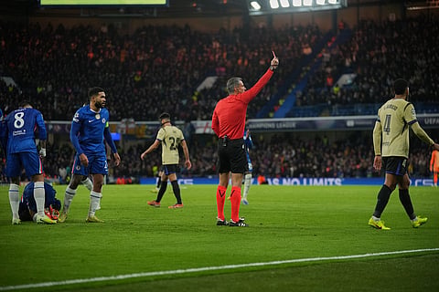 Referee Slavko Vincic shows a red card to Barcelona's Ronald Araujo during the Champions League opening phase soccer match between Chelsea and Barcelona in London.