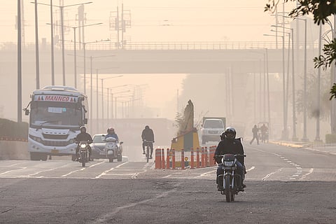 Commuters make their way amid low-visibility as the city's air quality continues to deteriorate, in Noida.