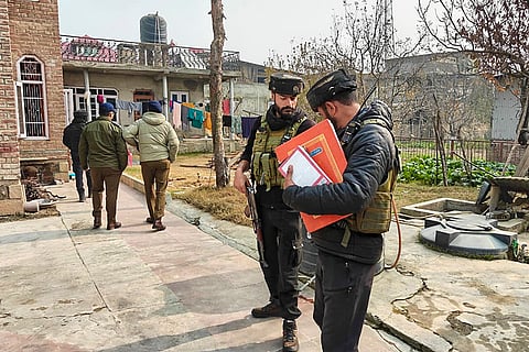 Police with CRPF personnel carry out a search at the residence of a person linked to banned Jamaat-e-Islami, in Pulwama.