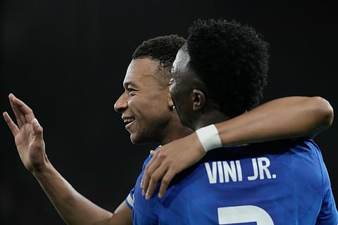 Real Madrid's Kylian Mbappe, left, celebrates with his teammate Vinicius Junior after scoring his side's fourth goal during the Champions League opening phase soccer match between Olympiacos and Real Madrid, in in Piraeus port, near Athens, Greece.