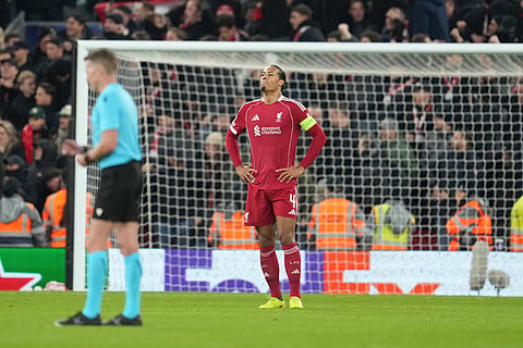 Liverpool's Virgil van Dijk reacts after PSV's Couhaib Driouech scored his side's fourth goal during the Champions League opening phase soccer match between Liverpool and PSV in Liverpool, England.