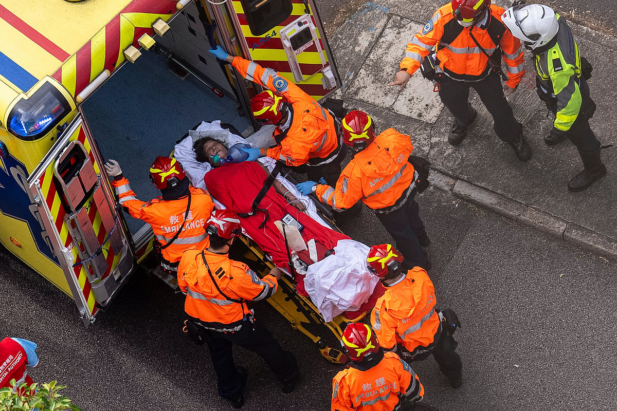 Health workers vacuating woman, hong kong fire. -  AP Photo/Chan Long Hei