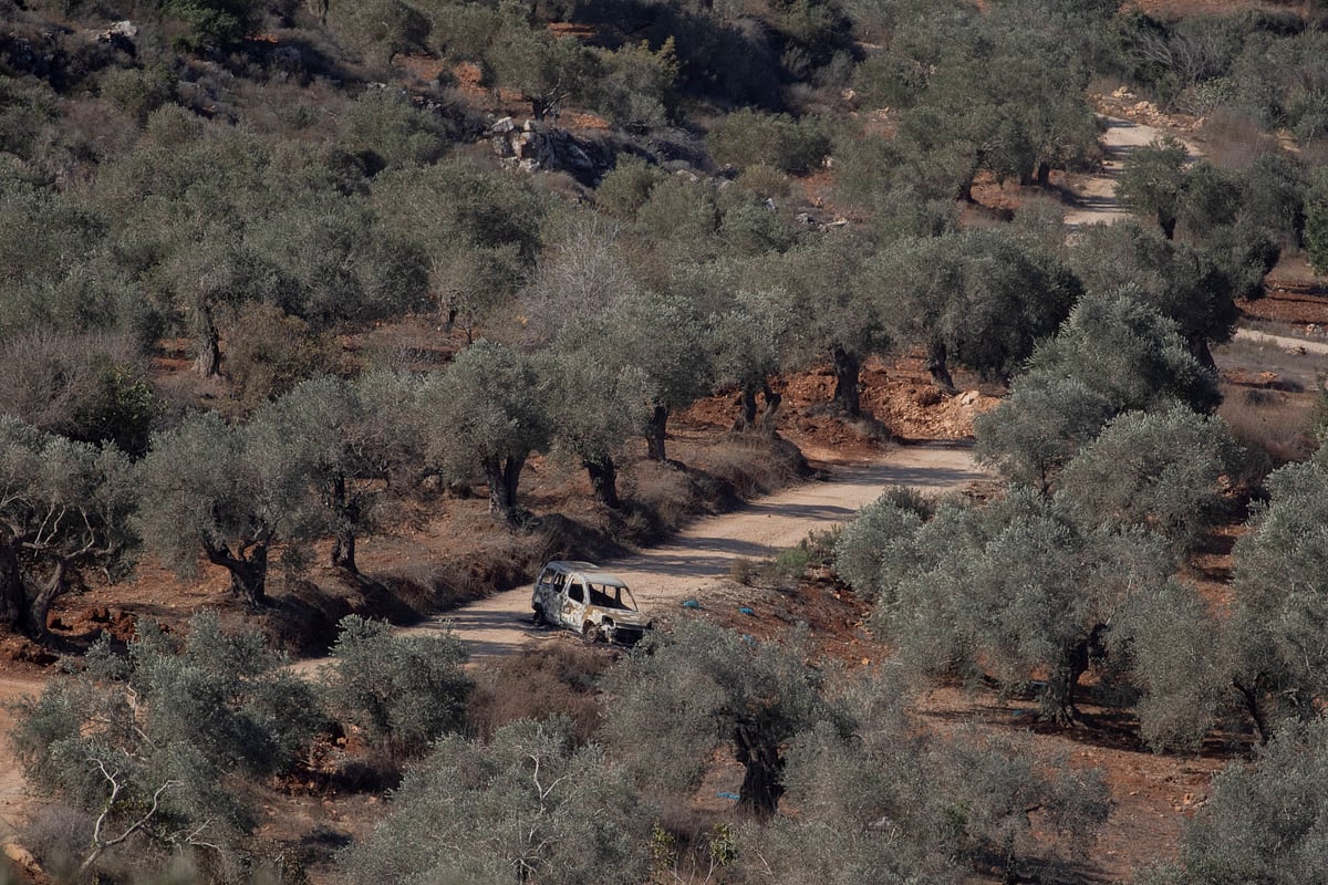 IMAGO / Middle East Images : A burned-out vehicle sits on a dirt road among olive trees in the village of Baita, south of Nablus in the occupied West Bank, on November 1, 2025. Tensions have risen in the area as settlers and Israeli forces confront Palestinian farmers during the olive harvest season. 
