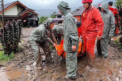 Rescuers carry the body of a flood victim in Malalak, West Sumatra, Indonesia.