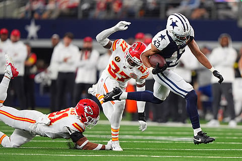 Dallas Cowboys running back Malik Davis, right, scores on a touchdown run past Kansas City Chiefs defensive back Chamarri Conner (27) and defensive back Jaden Hicks (21) during the first half of an NFL football game in Arlington, Texas. 