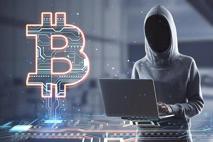 Hacker with laptop and Bitcoin logo