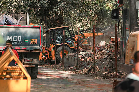 A backhoe loader being used during a demolition drive, near Jhandewalan Temple in Karol Bagh, New Delhi. 