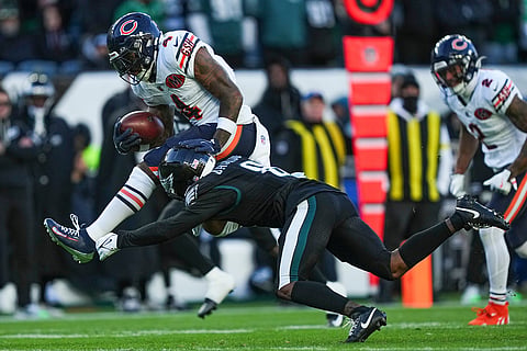 Chicago Bears running back D'Andre Swift (4), top, is tripped up by Philadelphia Eagles cornerback Adoree' Jackson (8) during the first half of an NFL football game in Philadelphia. 