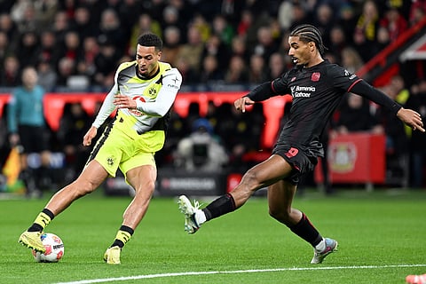 Bayer's Loïc Badé, right, and Borussia's Felix Nmecha fight for the ball during the German Bundesliga soccer match between Bayer Leverkusen and Borussia Dortmund in Leverkusen, Germany.