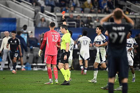 Referee Joe Dickerson issues a red card to San Diego FC goalkeeper Pablo Sisniega (13) during the second half of an MLS Western Conference final soccer match against Vancouver Whitecaps in San Diego.