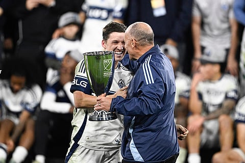 Carl Valentine, right, presents the trophy to Vancouver Whitecaps midfielder Ryan Gauld after a MLS Western Conference final soccer match win against San Diego FC in San Diego.