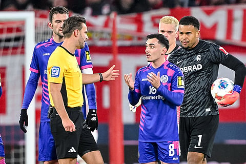 Referee Benjamin Brand, left gestures after showing Paul Nebel of 1. FSV Mainz 05 the red card, during a German Bundesliga soccer match between SC Freiburg and 1. FSV Mainz 05, in Freiburg im Breisgau, Germany.