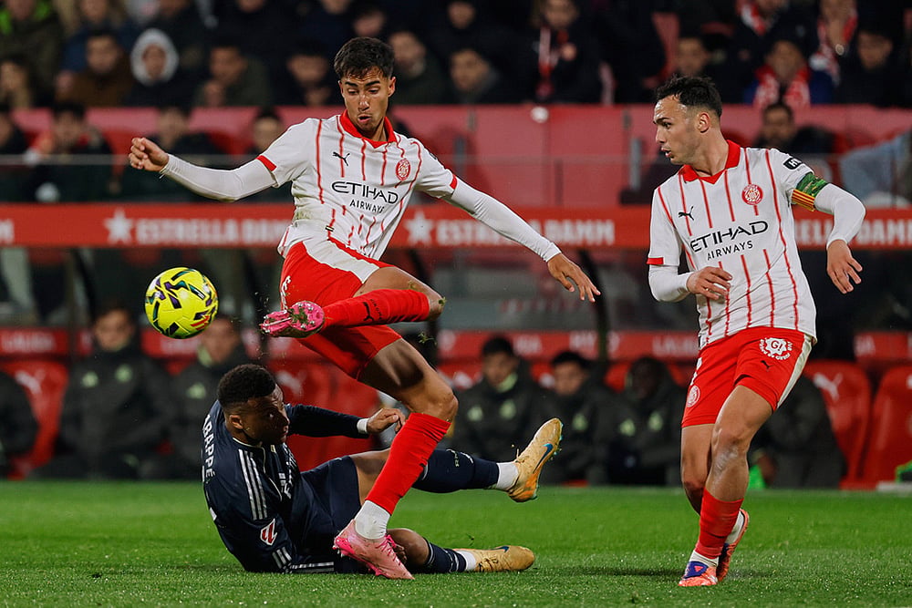 | Photo: AP/Joan Monfort : Real Madrid's Kylian Mbappe, left, vies for the ball with Girona's Vitor Reis during a Spanish La Liga soccer match between Girona and Real Madrid, in Girona, Spain.